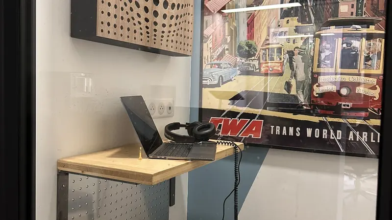 Intérieur de la cabine : tablette en bois, ordinateur et casque